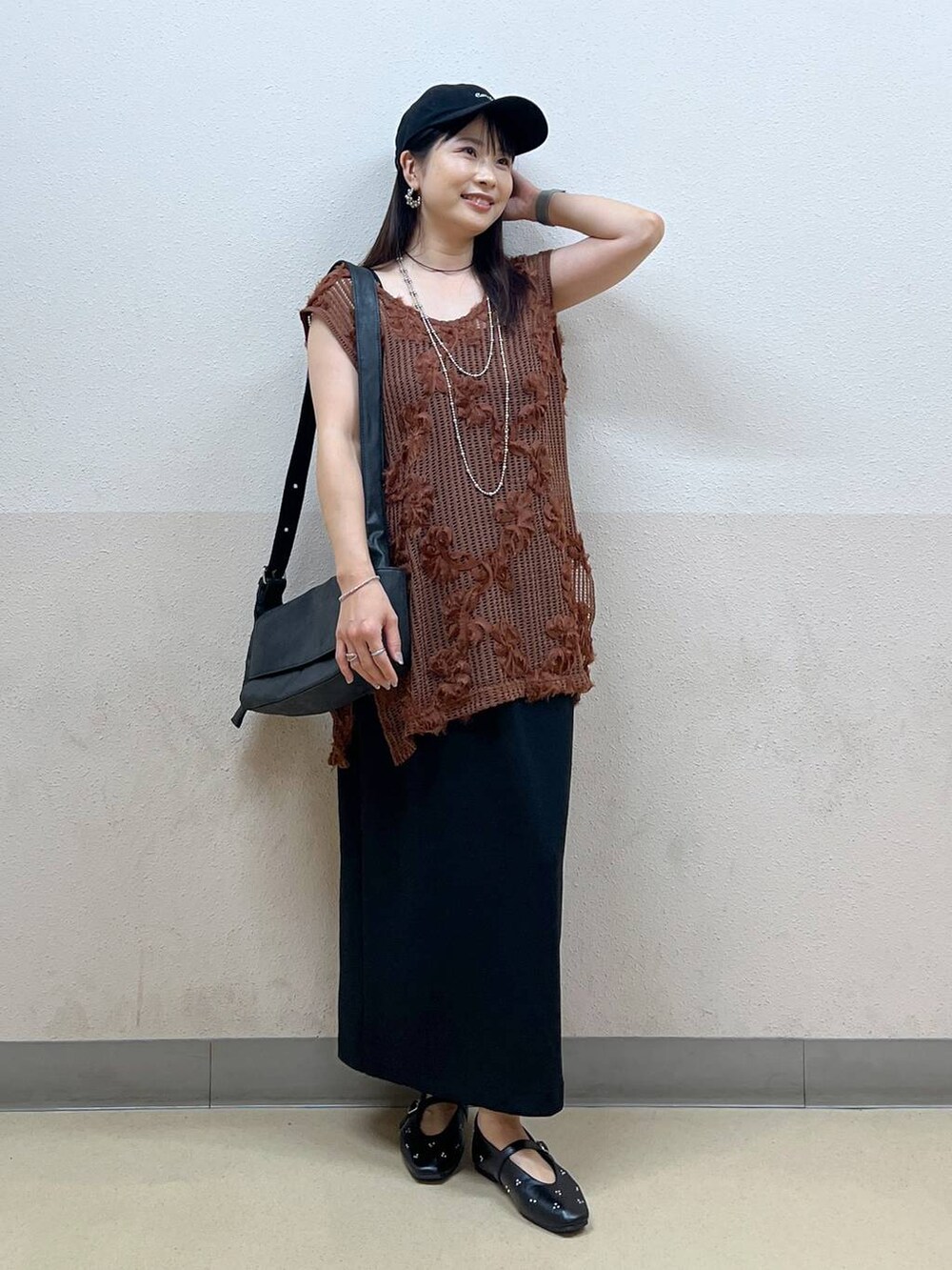 ブラック系のスカート、ブラック系のパンプス、ブラック系のショルダーバッグを着用したレディースの夏コーディネートの4枚目の写真