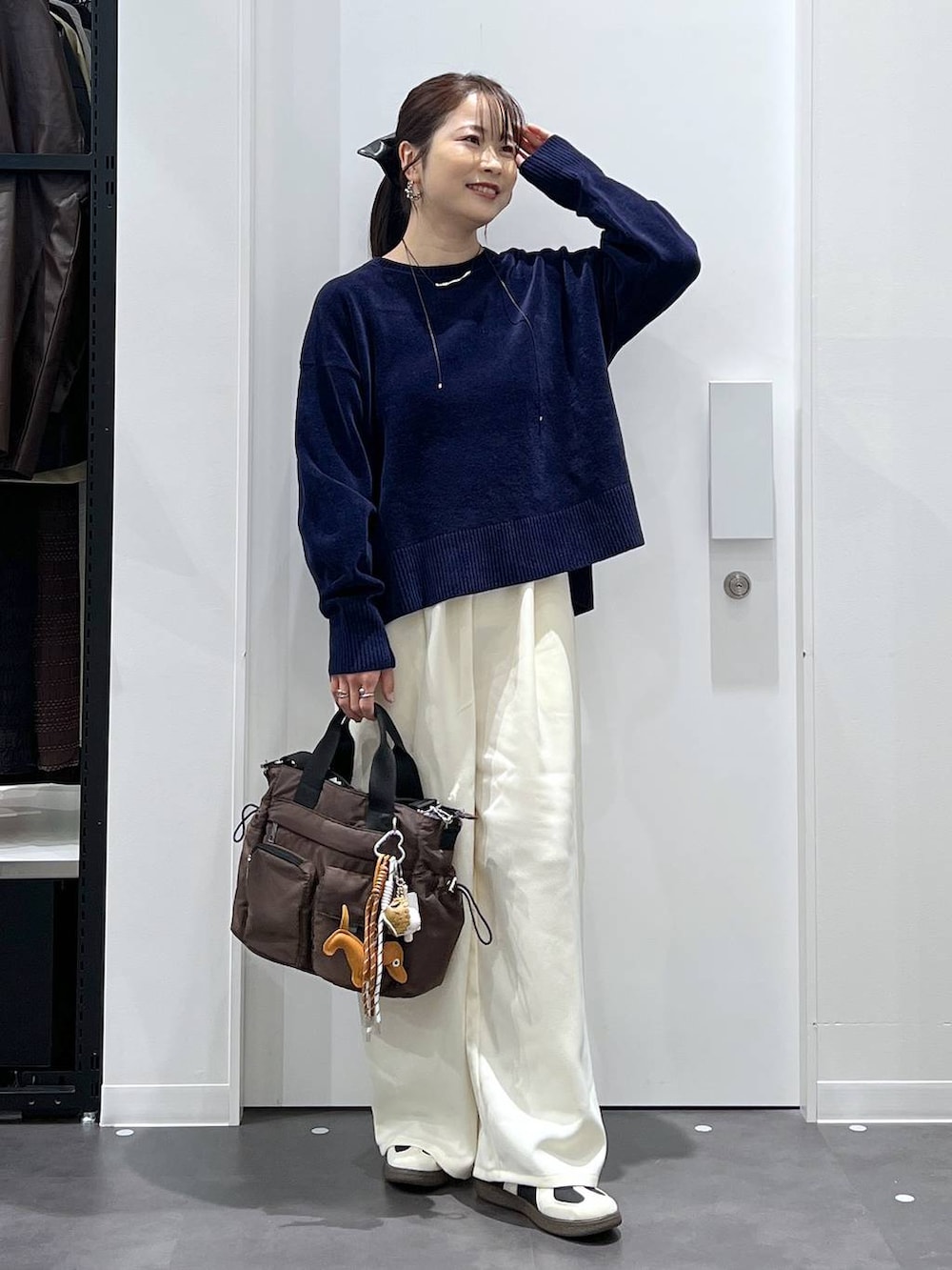 ブラック系のスニーカー、ブラウン系のトートバッグ、ホワイト系のその他パンツを着用したレディースの冬コーディネートの5枚目の写真