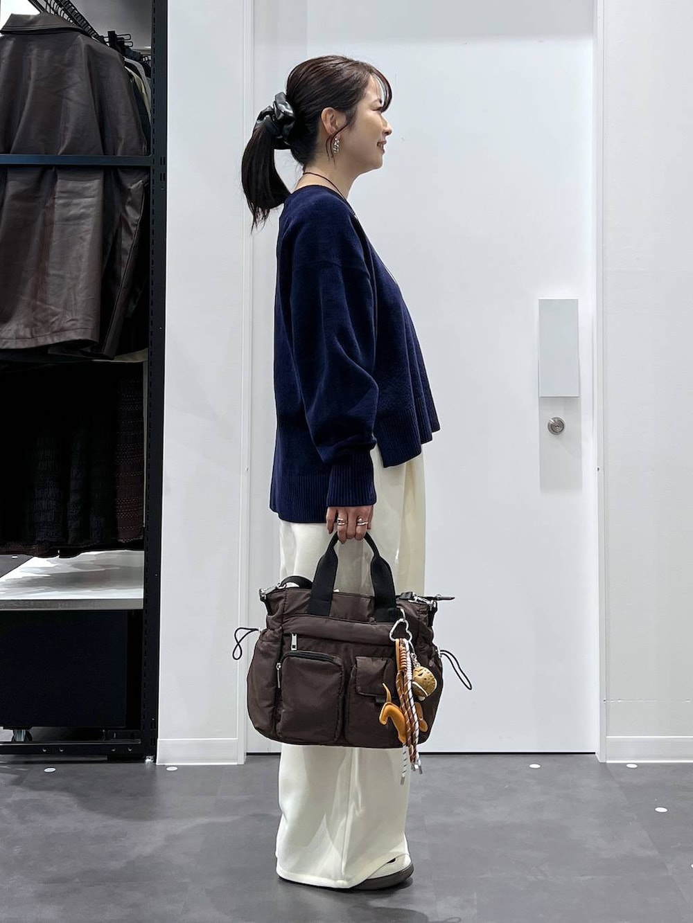 ブラック系のスニーカー、ブラウン系のトートバッグ、ホワイト系のその他パンツを着用したレディースの冬コーディネートの2枚目の写真