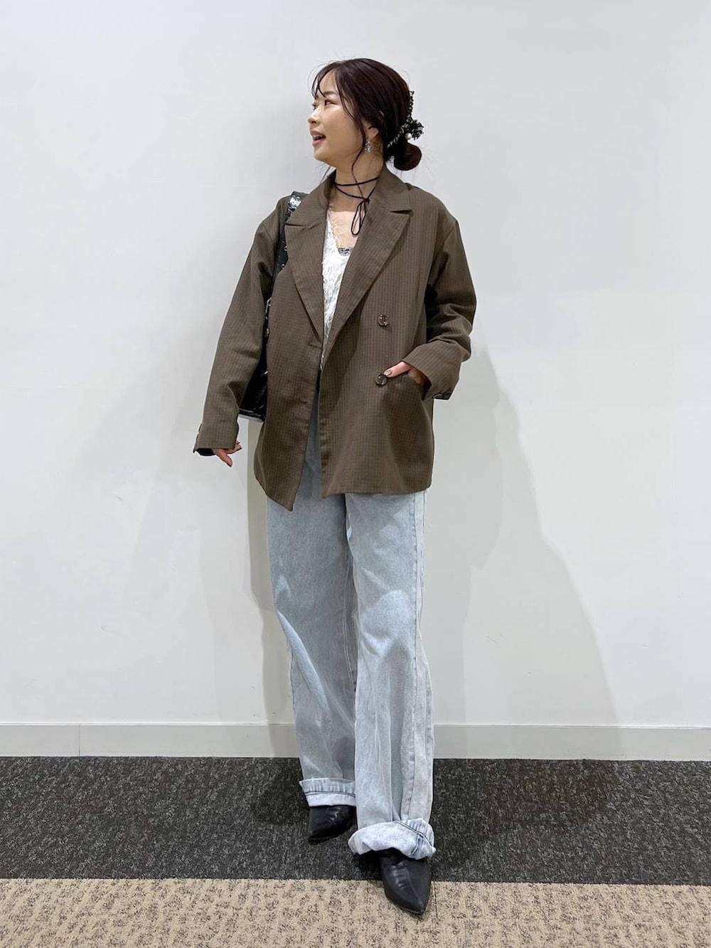 ブルー系のデニムパンツ、ブラック系のショルダーバッグ、ブラウン系のテーラードジャケットを着用したレディースの秋コーディネートの2枚目の写真