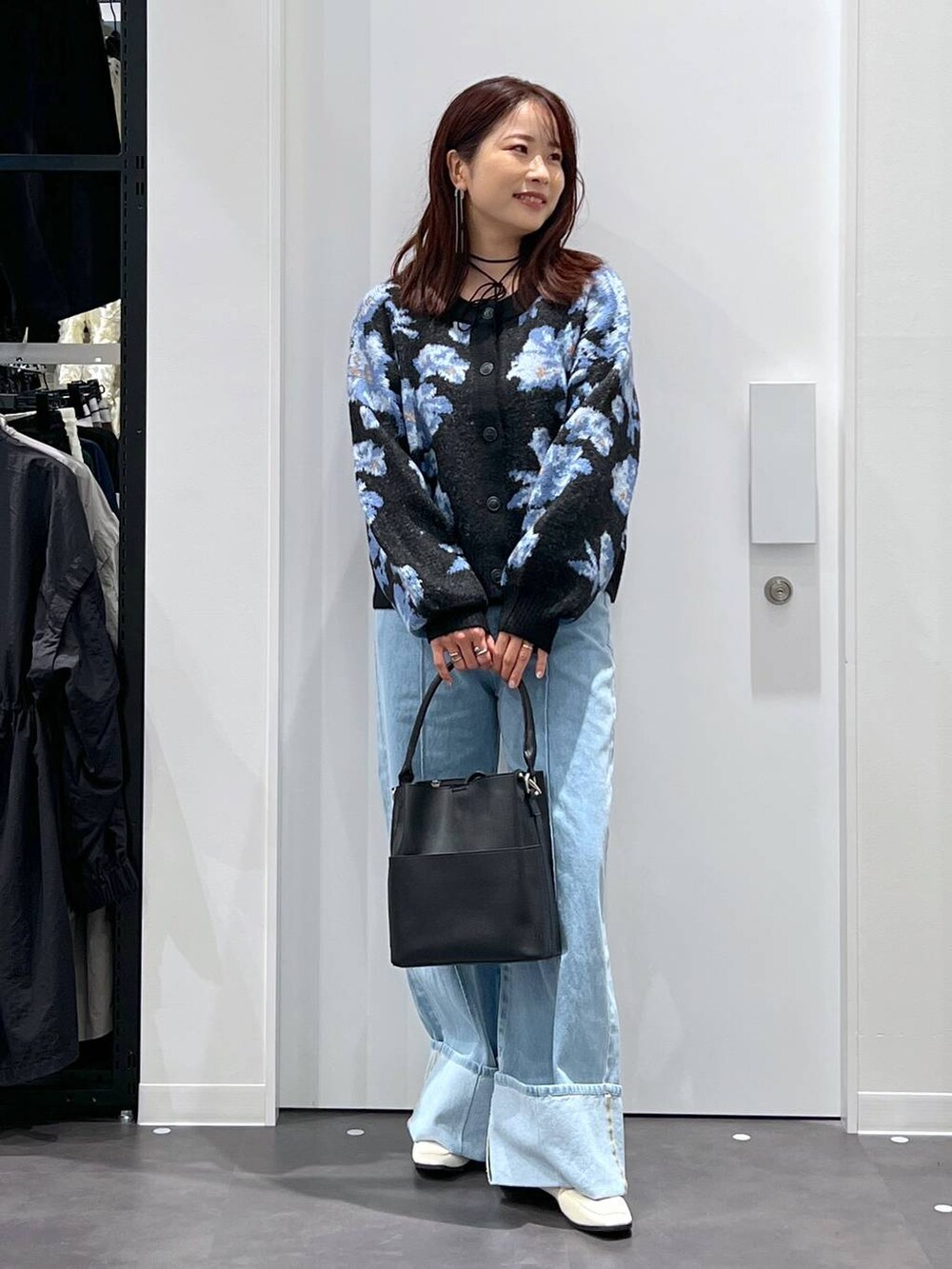 ブルー系のデニムパンツ、ブラック系のショルダーバッグ、ベージュ系のローファーを着用したレディースの秋コーディネートの4枚目の写真