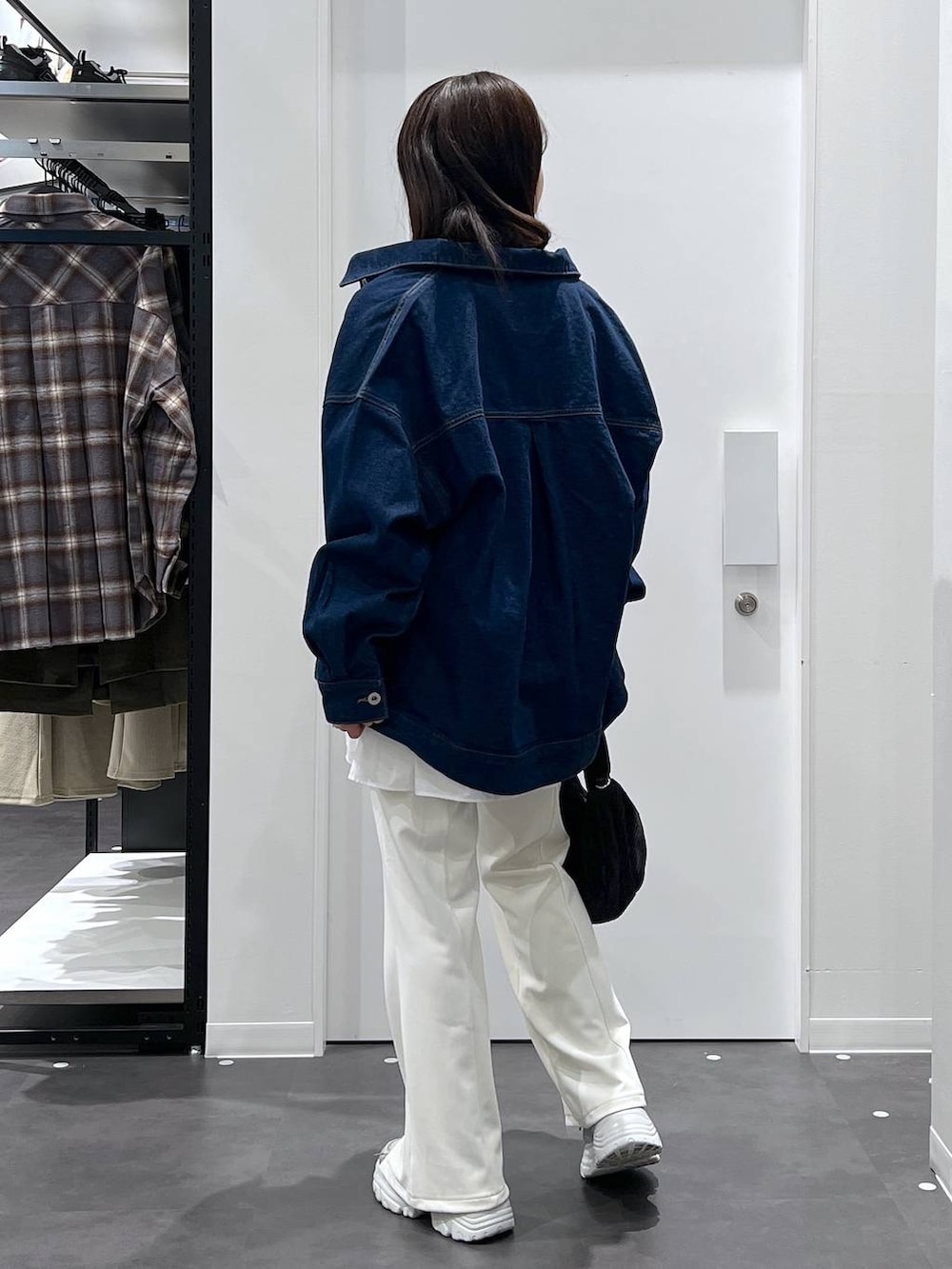 ホワイト系のTシャツ/カットソー、ブルー系のデニムジャケット、イエロー系のニット/セーターを着用したレディースの冬コーディネートの3枚目の写真