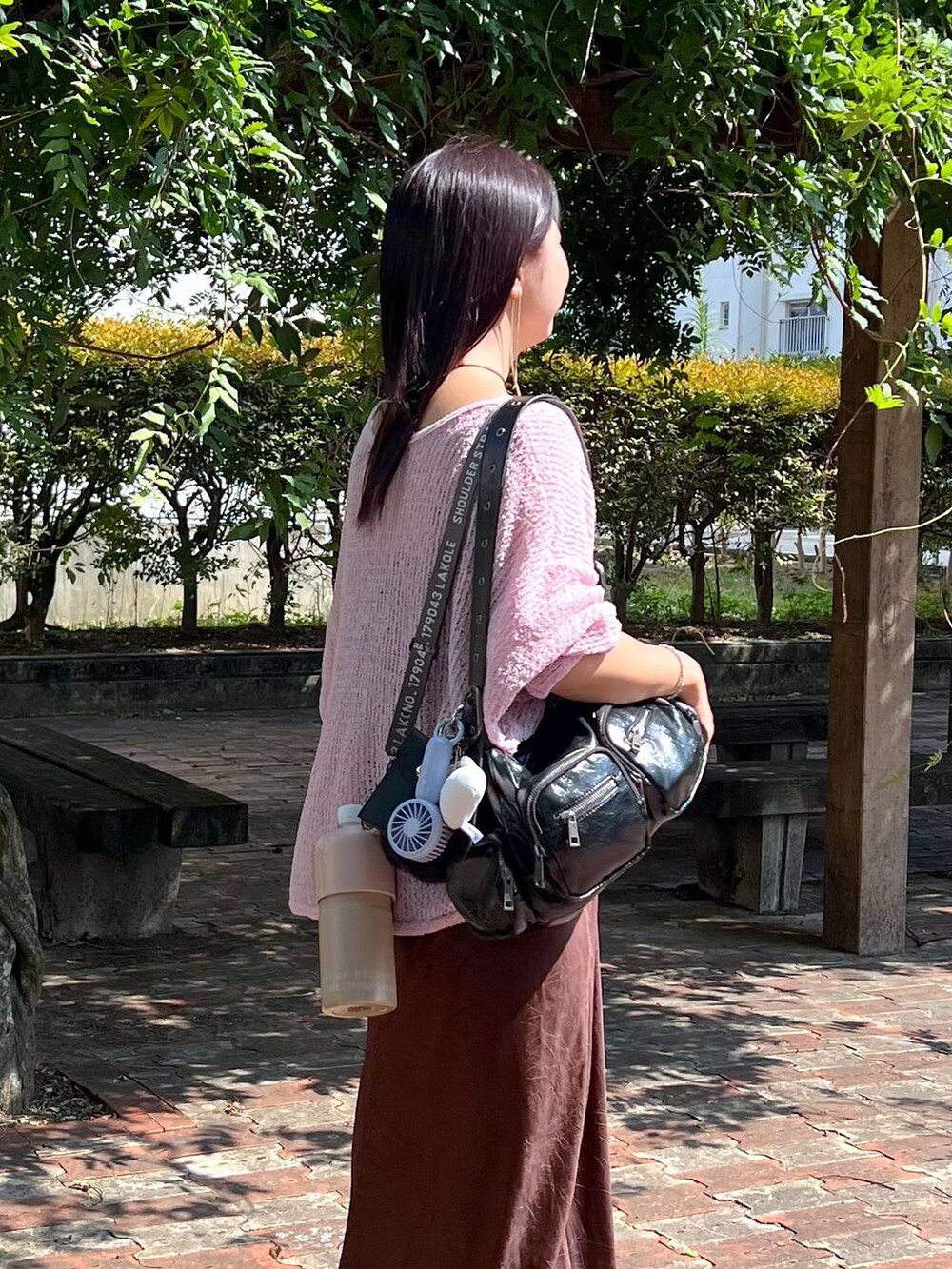 ピンク系のニット/セーター、ブラウン系のスカート、ブルー系の生活家電を着用したレディースの秋コーディネートの3枚目の写真