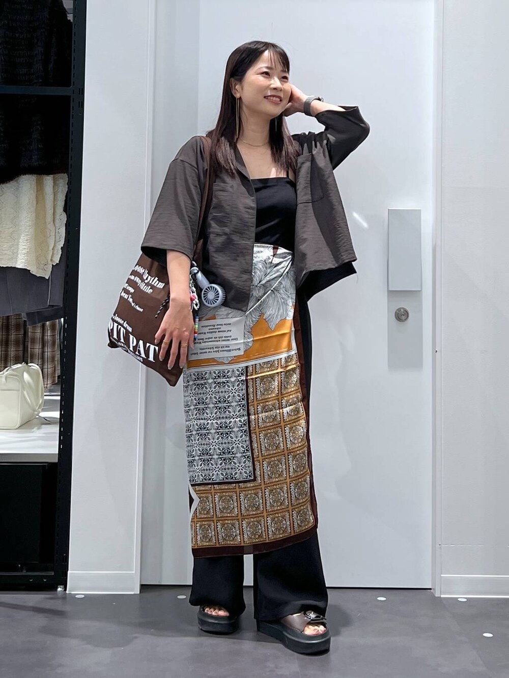 ブラック系のその他パンツ、ブラウン系のサンダル、グレー系のシャツ/ブラウスを着用したレディースの夏コーディネートの4枚目の写真