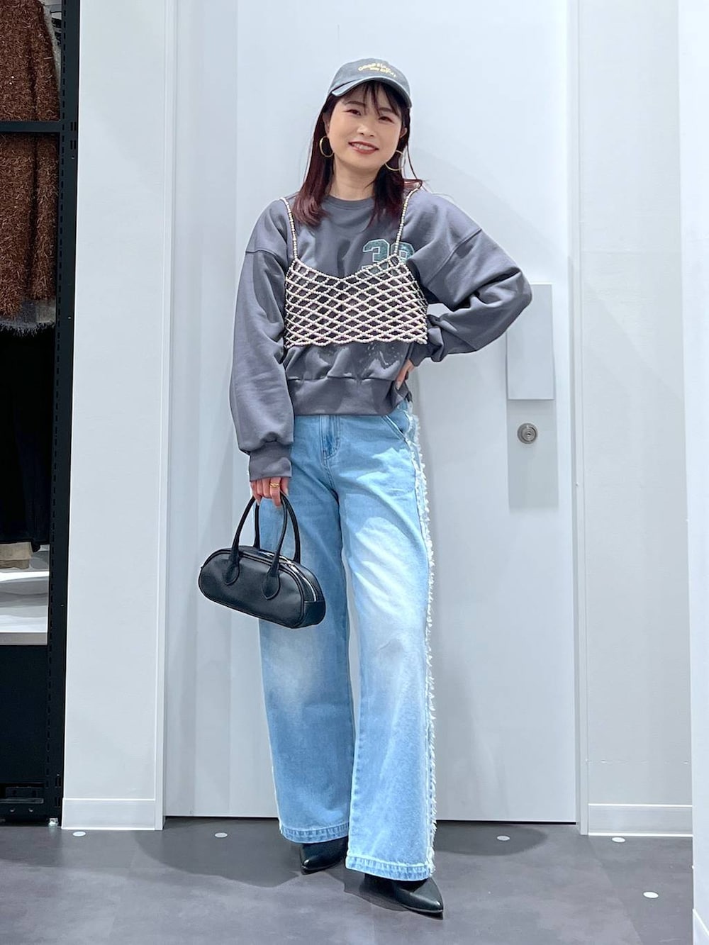 シルバー系のベスト、ブラック系のブーツ、ブラック系のボストンバッグを着用したレディースの冬コーディネートの4枚目の写真