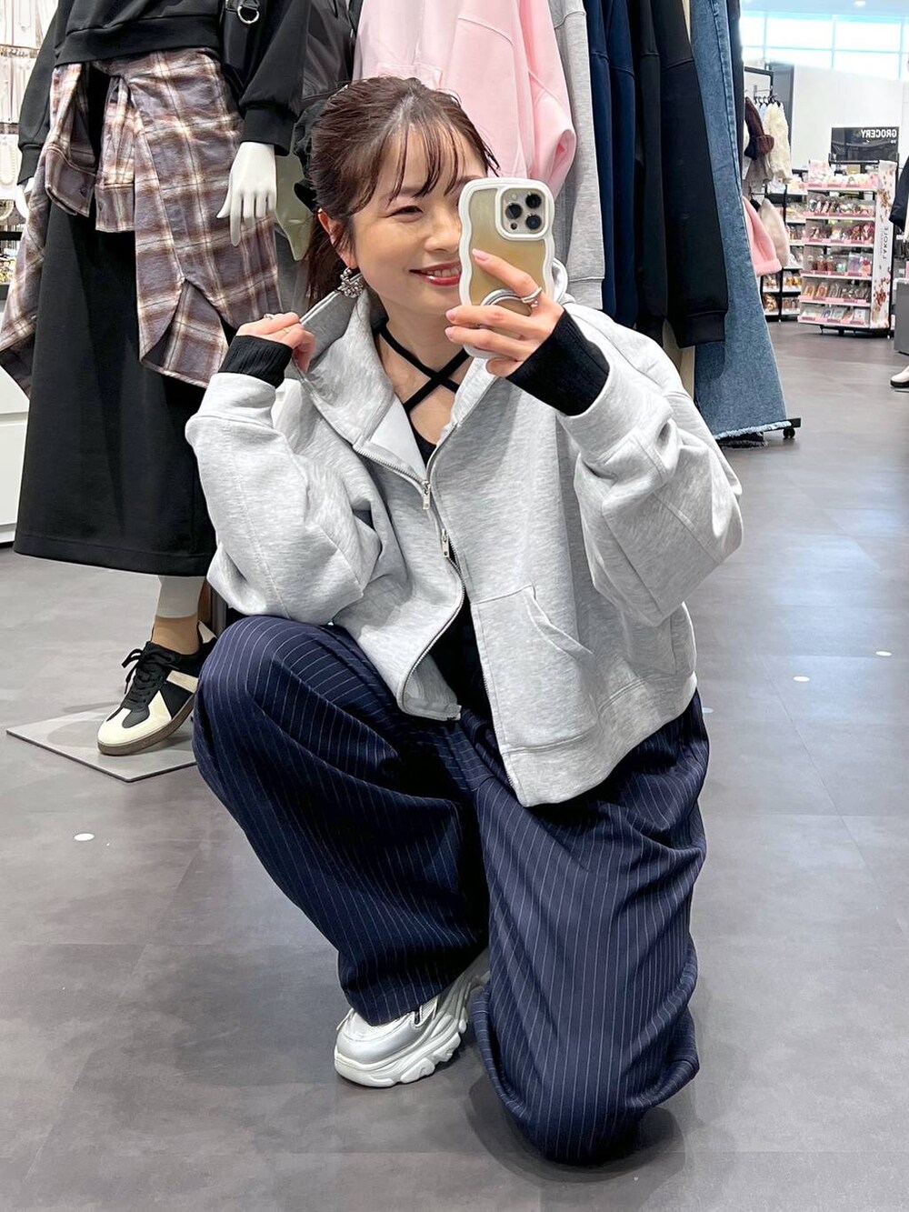 ブルー系のスラックス、ブラック系のニット/セーター、グレー系のパーカーを着用したレディースの冬コーディネートの3枚目の写真