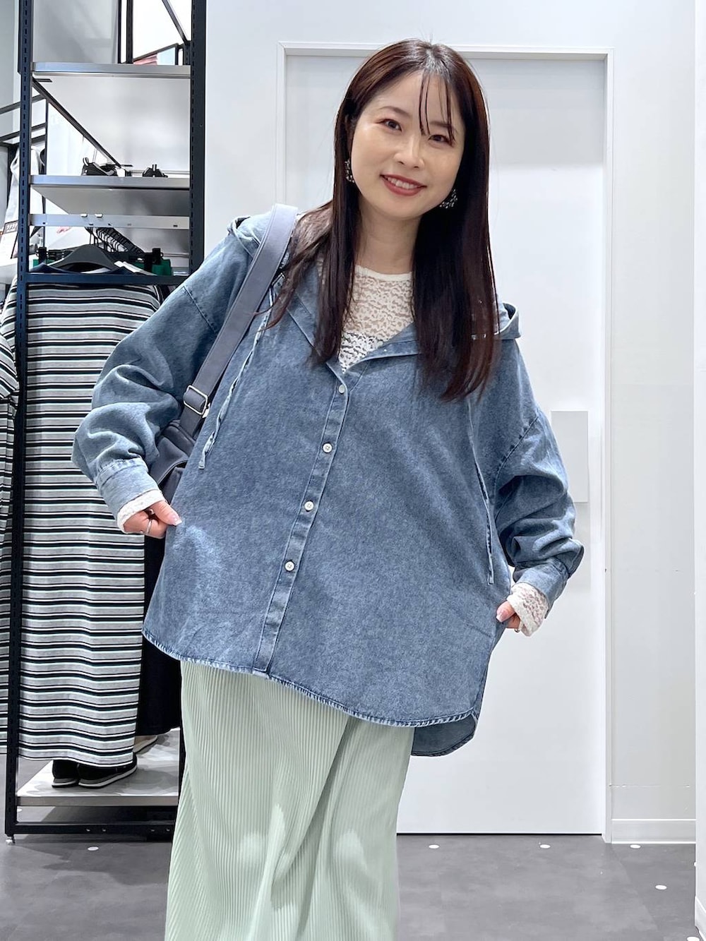 ブルー系のショルダーバッグ、ブルー系のその他トップス、ホワイト系のTシャツ/カットソーを着用したレディースの春コーディネートの4枚目の写真