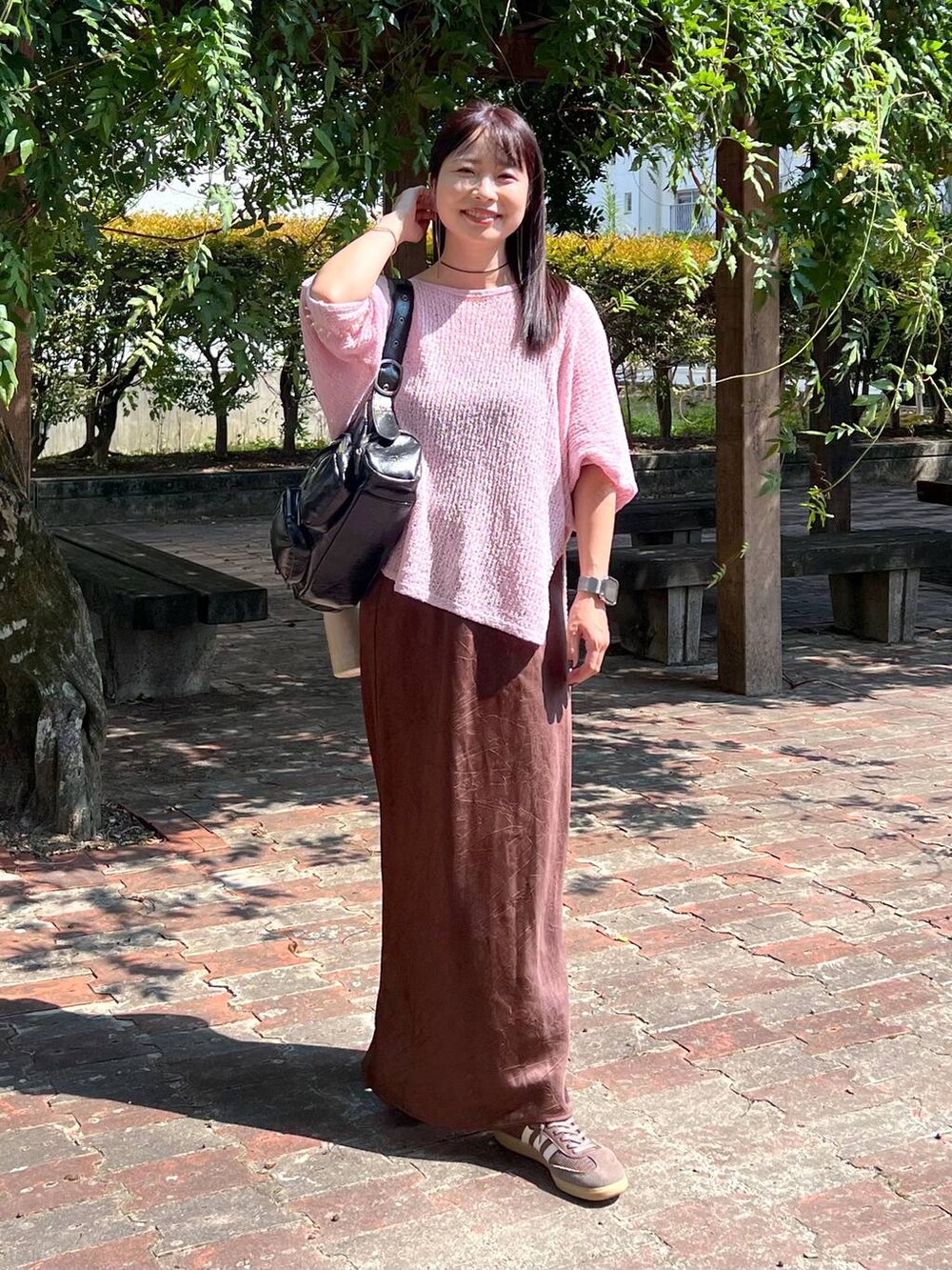 ピンク系のニット/セーター、ブラウン系のスカート、ブルー系の生活家電を着用したレディースの秋コーディネートの5枚目の写真