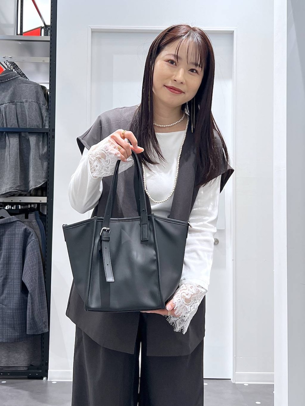ブラック系のレインシューズ、ブラック系のトートバッグ、グレー系のベストを着用したレディースの冬コーディネートの6枚目の写真