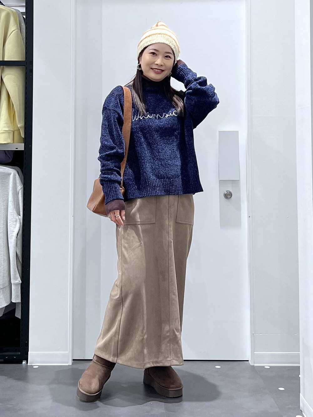 ブラウン系のブーツ、ブルー系のニット/セーター、ブラウン系のスカートを着用したレディースの冬コーディネートの5枚目の写真