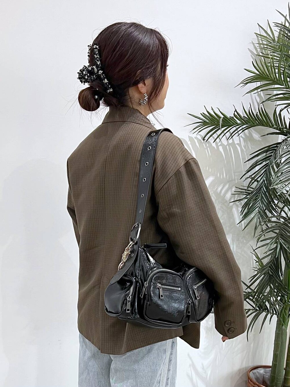 ブルー系のデニムパンツ、ブラック系のショルダーバッグ、ブラウン系のテーラードジャケットを着用したレディースの秋コーディネートの3枚目の写真