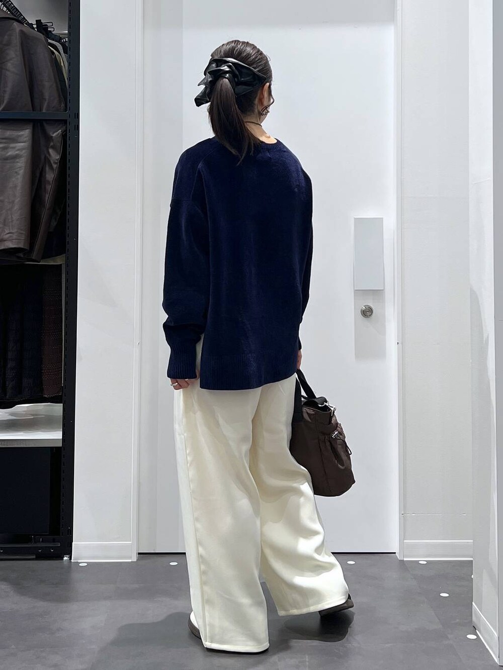 ブラック系のスニーカー、ブラウン系のトートバッグ、ホワイト系のその他パンツを着用したレディースの冬コーディネートの3枚目の写真