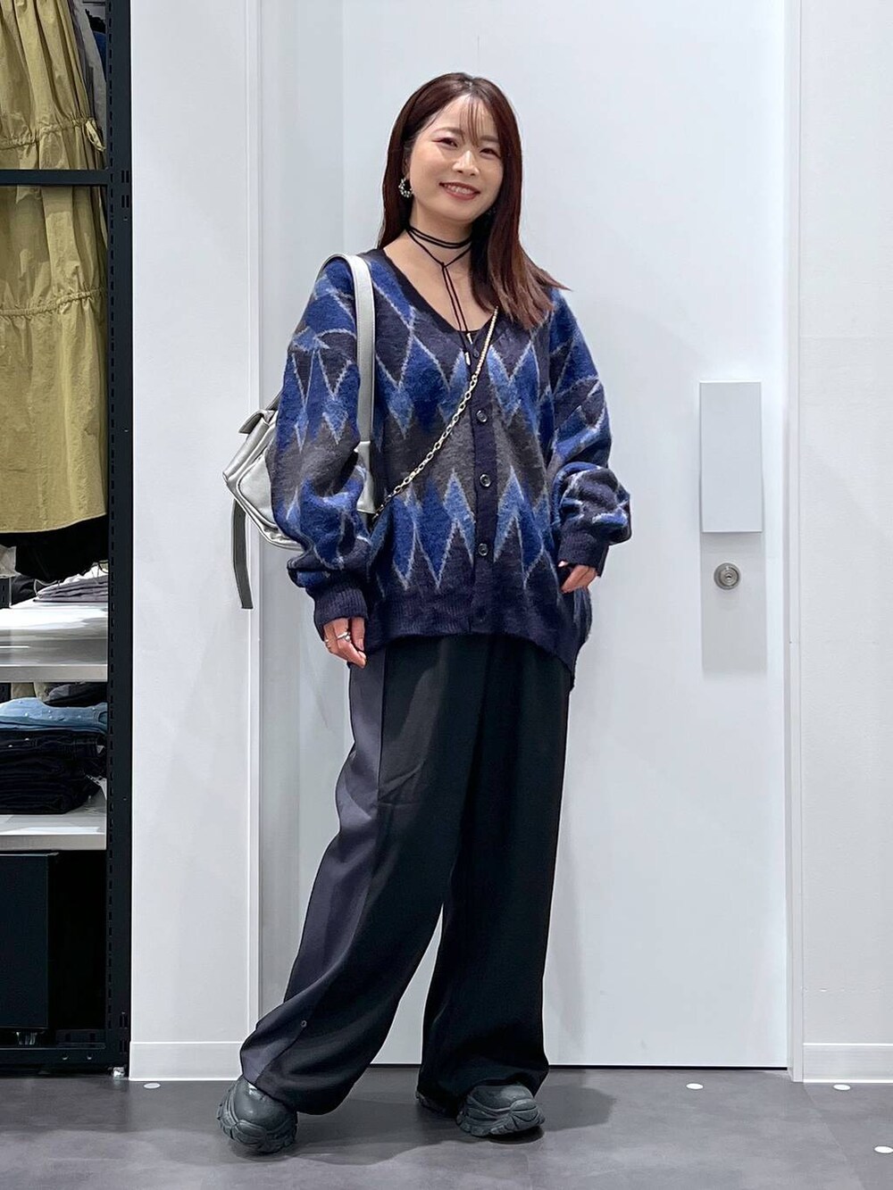 ブルー系のカーディガン/ボレロ、ブラック系のブーツ、その他のショルダーバッグを着用したレディースの秋コーディネートの4枚目の写真