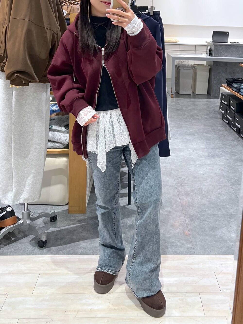 ブラウン系のパーカー、ブラウン系のスリッポン、ホワイト系のチュニックを着用したレディースの冬コーディネートの2枚目の写真