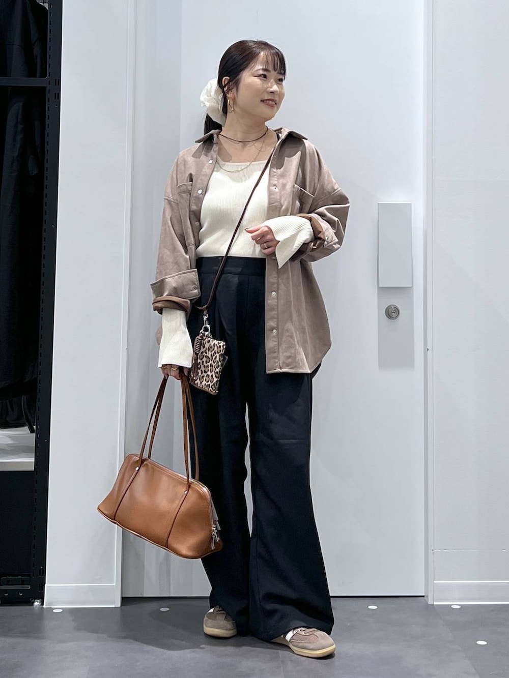 ブラウン系のボストンバッグ、ベージュ系のニット/セーター、ブラック系のその他パンツを着用したレディースの秋コーディネートの5枚目の写真