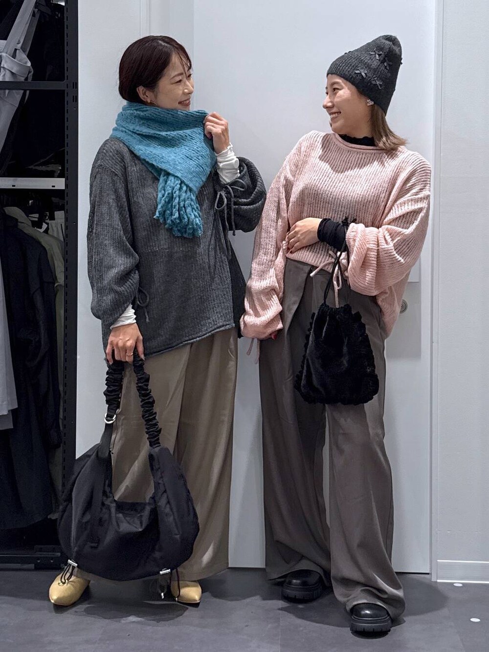 ブラック系のショルダーバッグ、ブラック系のブーツ、グレー系のニット/セーターを着用したレディースの秋コーディネートの2枚目の写真