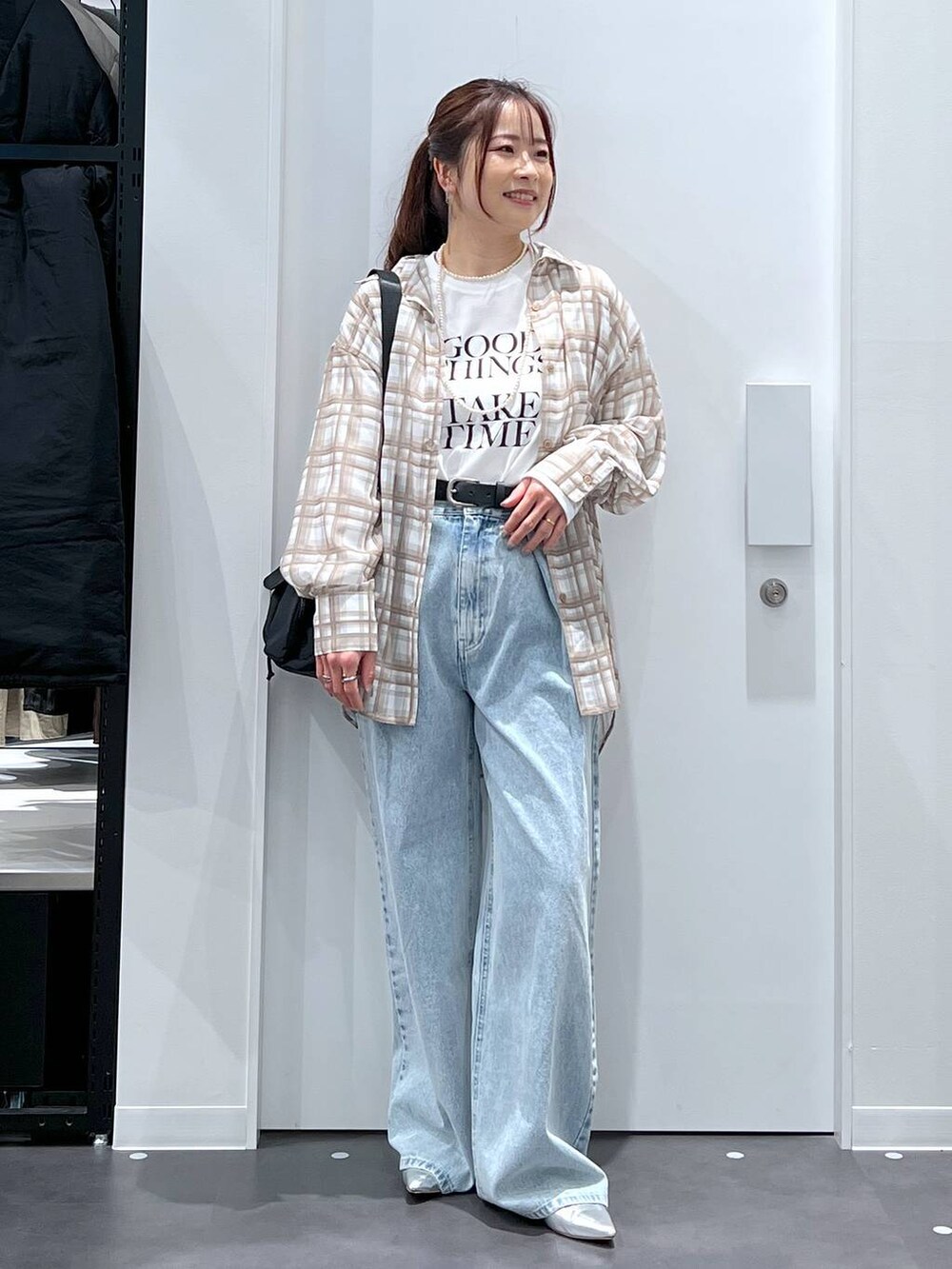 ブルー系のデニムパンツ、シルバー系のパンプス、ホワイト系のTシャツ/カットソーを着用したレディースの春コーディネートの4枚目の写真