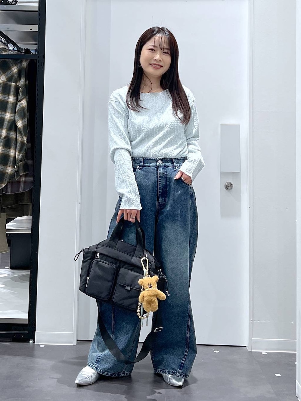 シルバー系のパンプス、ブラック系のトートバッグ、ブルー系のデニムパンツを着用したレディースの春コーディネートの5枚目の写真