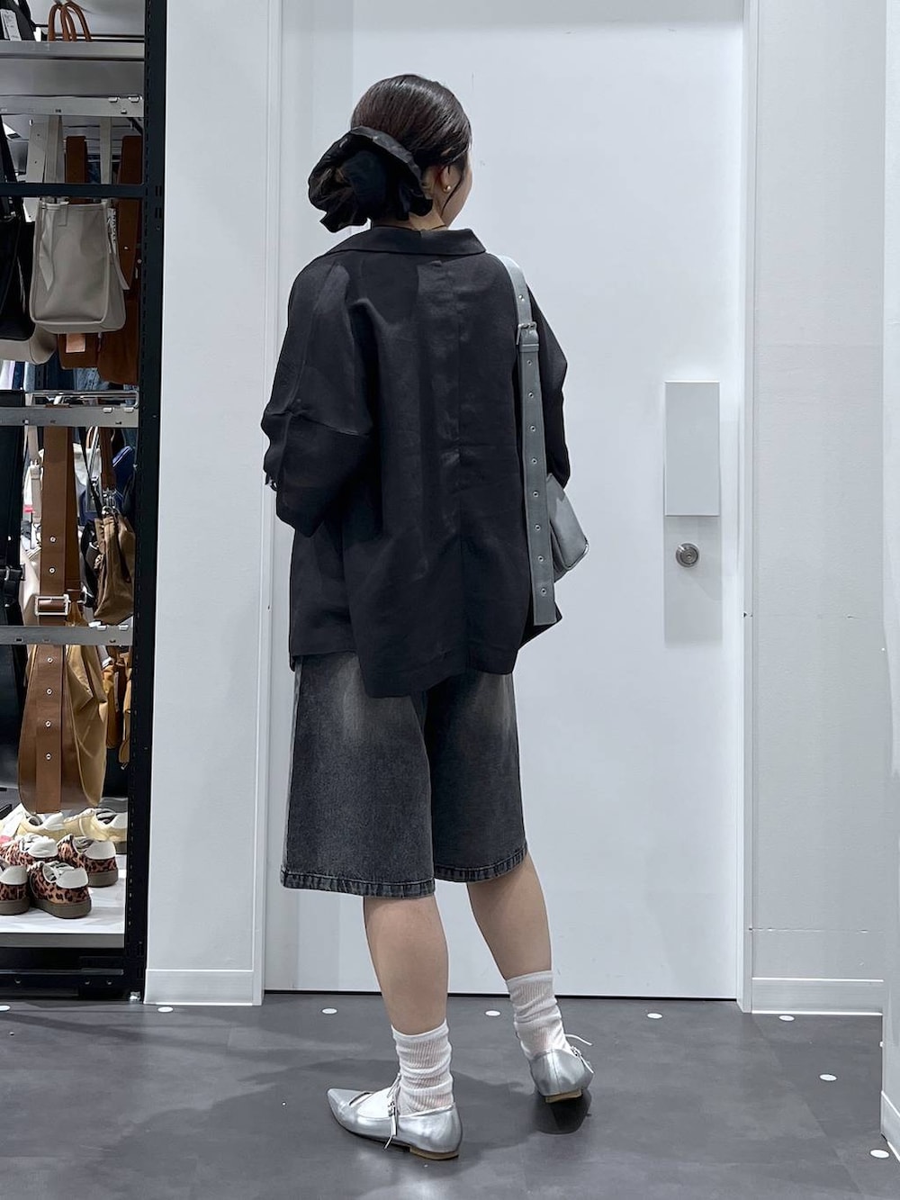シルバー系のパンプス、グレー系のショルダーバッグ、グレー系のテーラードジャケットを着用したレディースの夏コーディネートの3枚目の写真