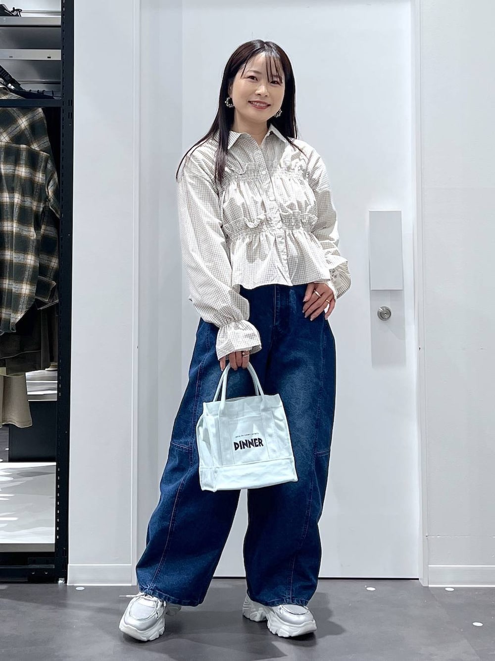 グリーン系のトートバッグ、ブルー系のデニムパンツ、ベージュ系のシャツ/ブラウスを着用したレディースの春コーディネートの5枚目の写真