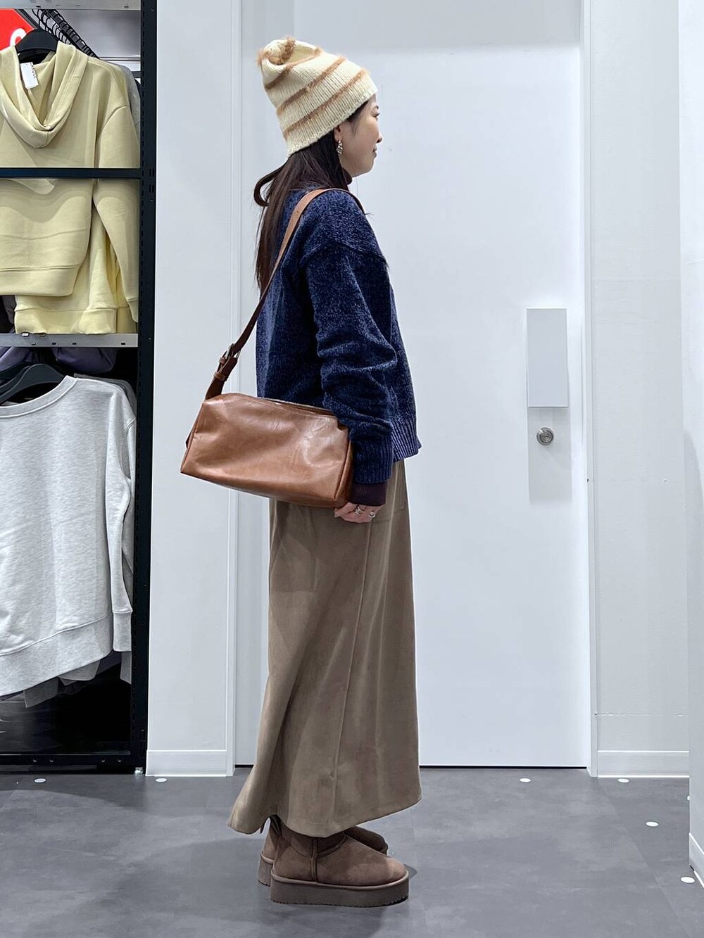 ブラウン系のブーツ、ブルー系のニット/セーター、ブラウン系のスカートを着用したレディースの冬コーディネートの2枚目の写真