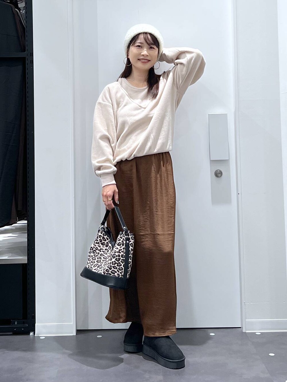 その他のショルダーバッグ、ブラウン系のスカート、ブラック系のブーツを着用したレディースの秋コーディネートの4枚目の写真