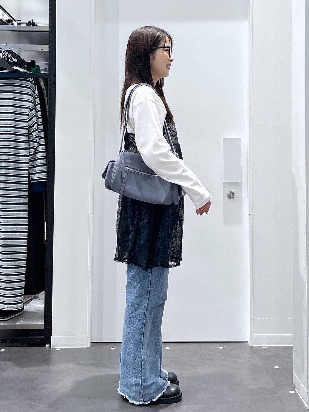 ブルー系のショルダーバッグ、ホワイト系のTシャツ/カットソー、ブラック系のサンダルを着用したレディースの春コーディネートの2枚目の写真