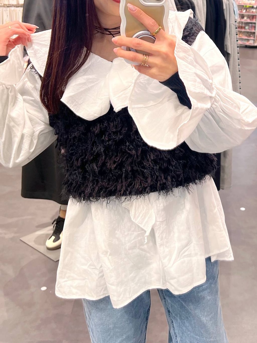 ブラック系のベスト、ブルー系のデニムパンツ、ホワイト系のシャツ/ブラウスを着用したレディースの冬コーディネートの3枚目の写真