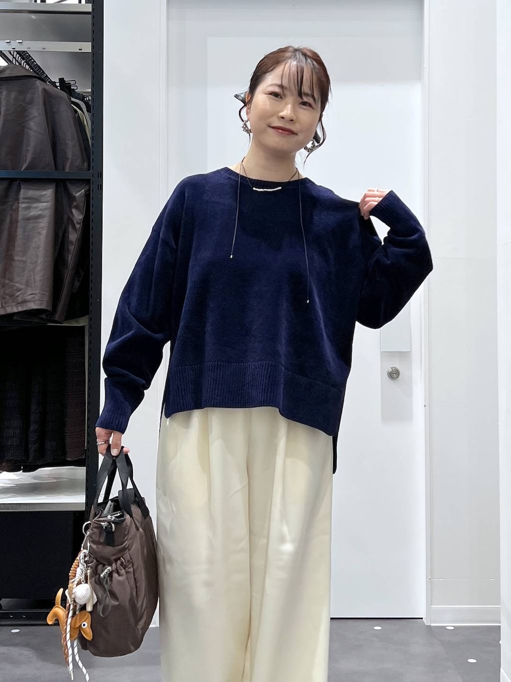 ブラック系のスニーカー、ブラウン系のトートバッグ、ホワイト系のその他パンツを着用したレディースの冬コーディネートの4枚目の写真