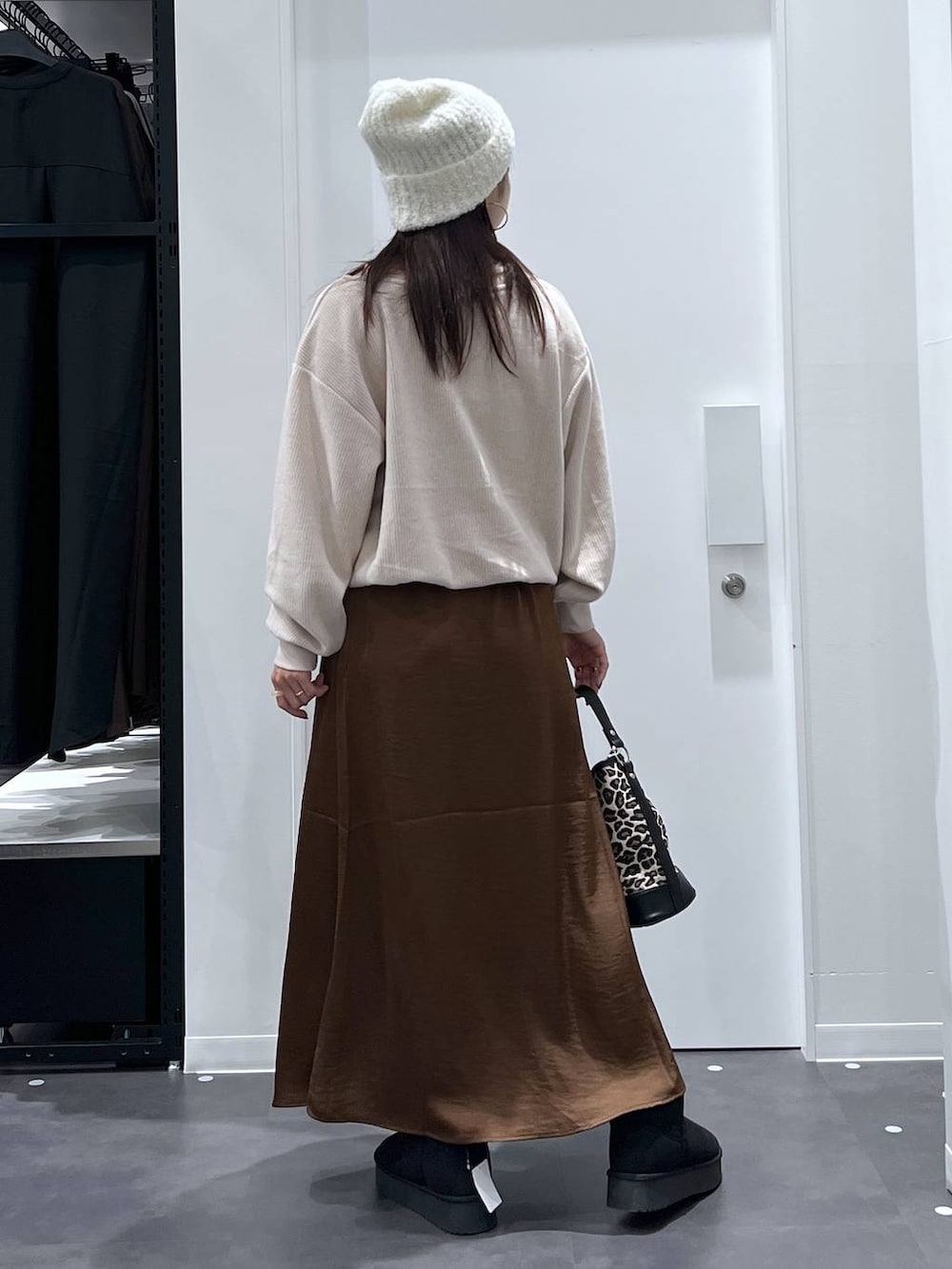 その他のショルダーバッグ、ブラウン系のスカート、ブラック系のブーツを着用したレディースの秋コーディネートの3枚目の写真