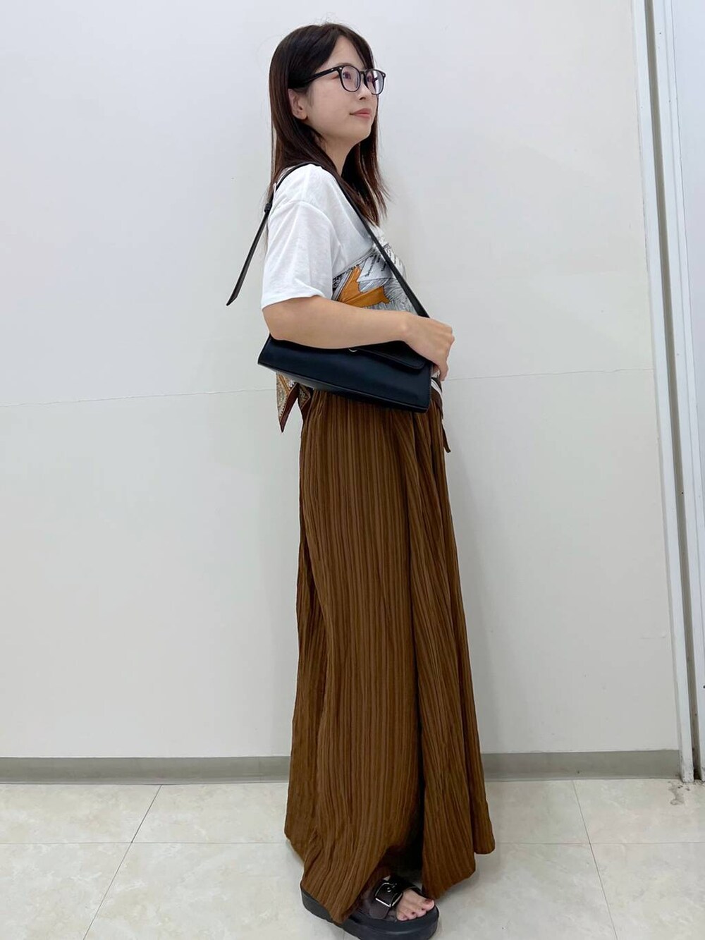 ホワイト系のTシャツ/カットソー、ブラック系のショルダーバッグ、ブラウン系のその他パンツを着用したレディースの秋コーディネートの2枚目の写真