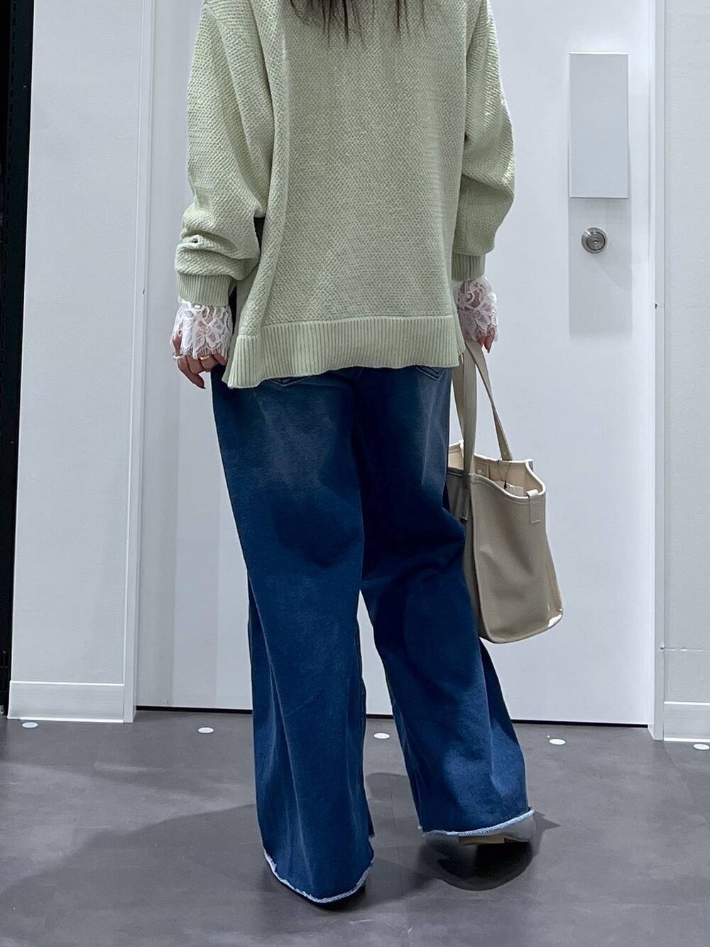 シルバー系のパンプス、ホワイト系のトートバッグ、ブルー系のその他パンツを着用したレディースの春コーディネートの3枚目の写真