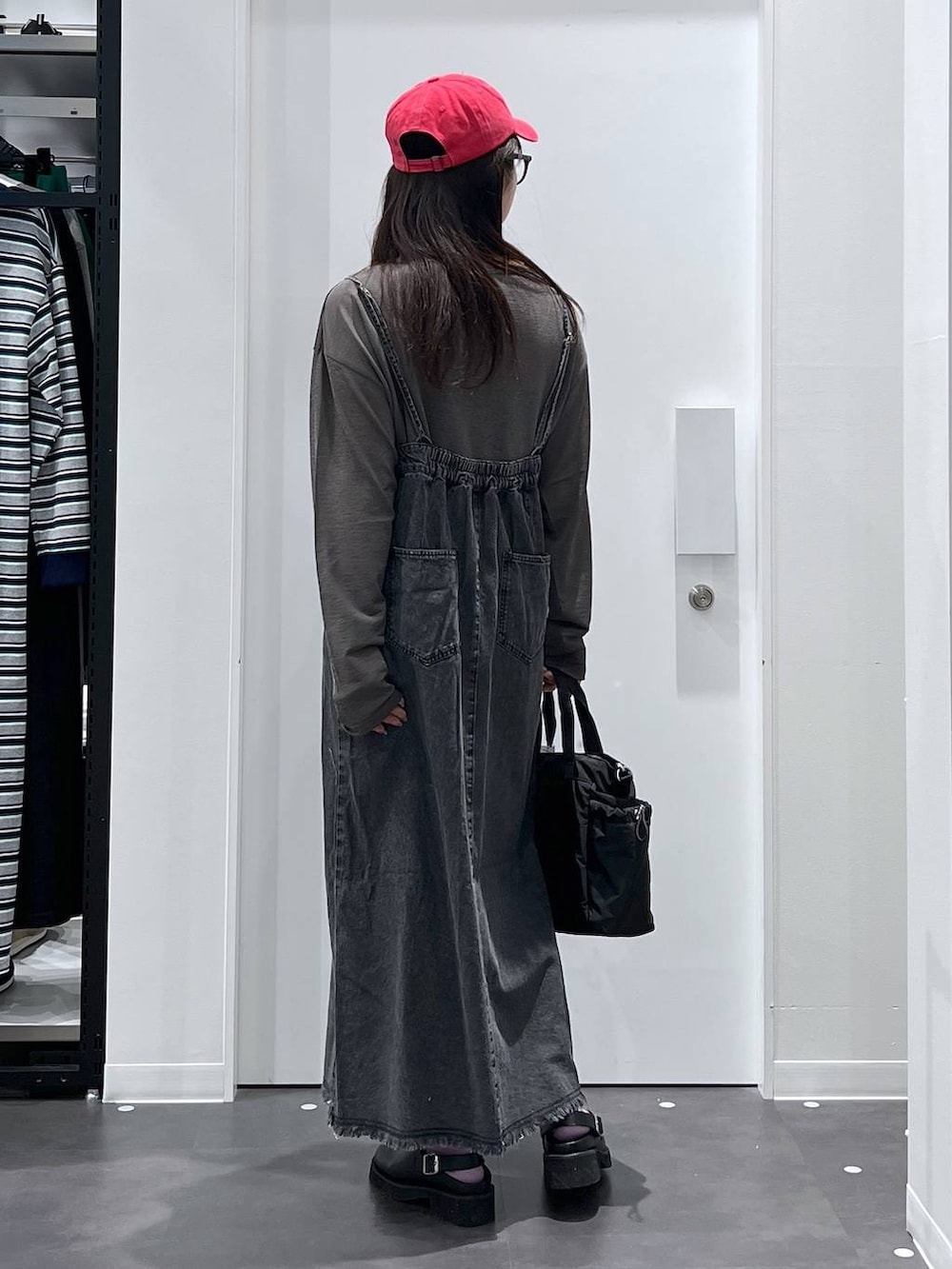 ブラック系のトートバッグ、ブラック系のサンダル、ブラック系のワンピースを着用したレディースの春コーディネートの3枚目の写真