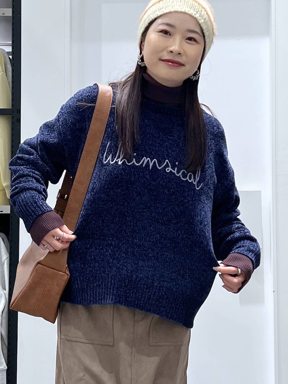 ブラウン系のブーツ、ブルー系のニット/セーター、ブラウン系のスカートを着用したレディースの冬コーディネートの4枚目の写真