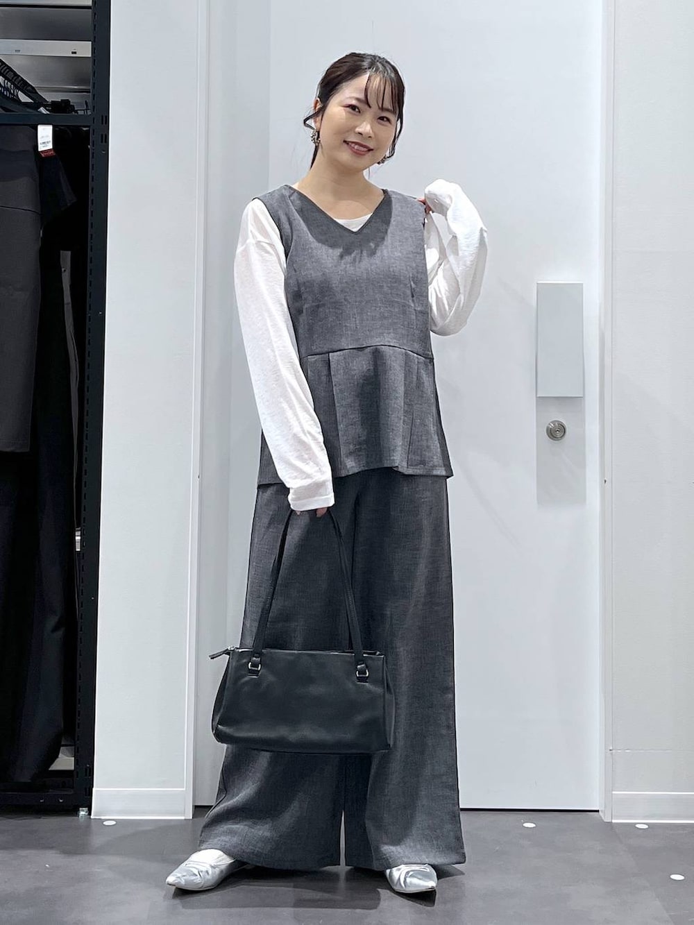 シルバー系のパンプス、ブラック系のハンドバッグ、ブラック系のその他パンツを着用したレディースの春コーディネートの4枚目の写真