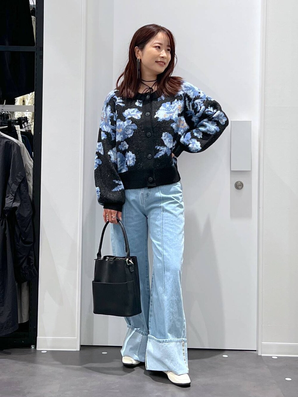ブルー系のデニムパンツ、ブラック系のショルダーバッグ、ベージュ系のローファーを着用したレディースの秋コーディネートの3枚目の写真