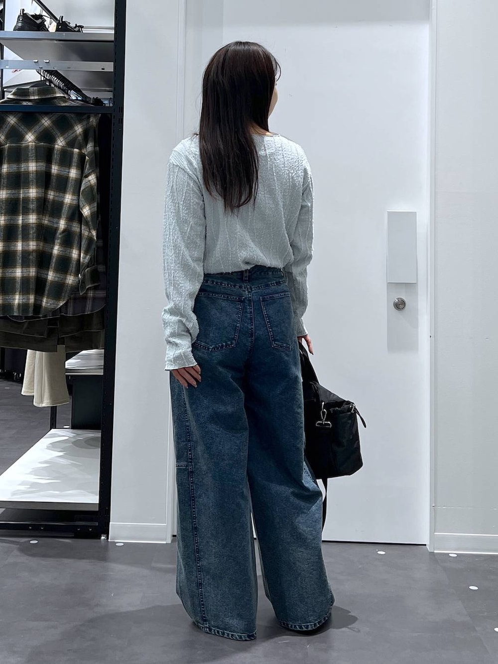 シルバー系のパンプス、ブラック系のトートバッグ、ブルー系のデニムパンツを着用したレディースの春コーディネートの4枚目の写真