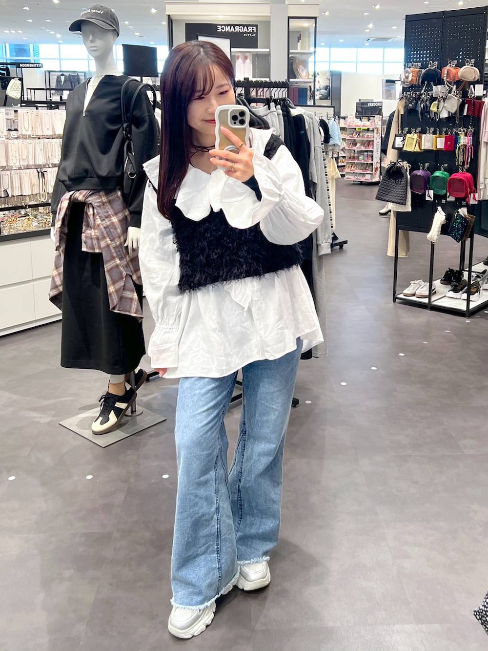 ブラック系のベスト、ブルー系のデニムパンツ、ホワイト系のシャツ/ブラウスを着用したレディースの冬コーディネートの2枚目の写真