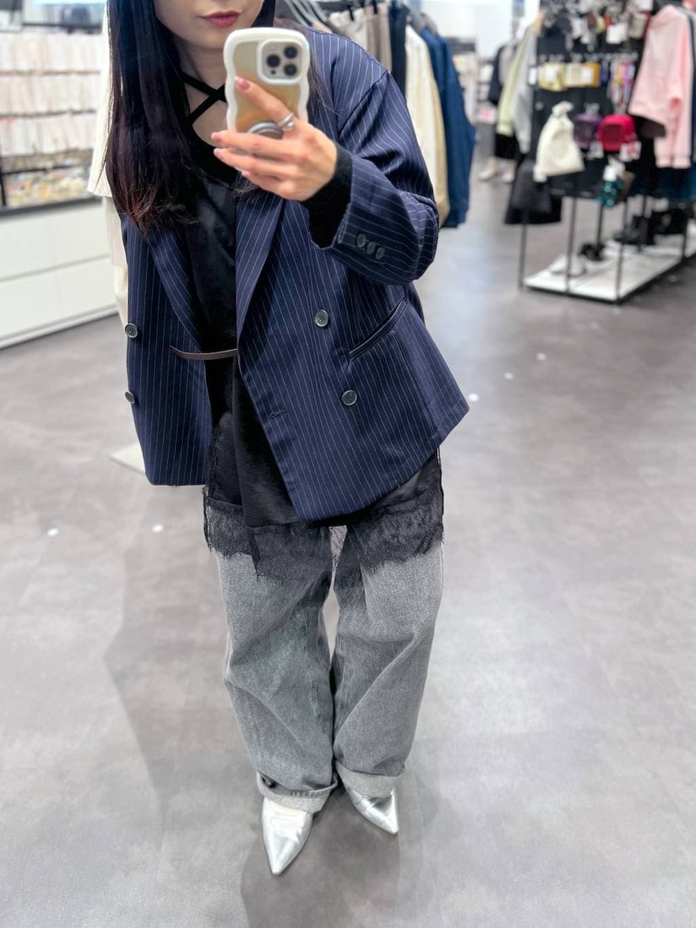 シルバー系のパンプス、ブラック系のデニムパンツ、ブルー系のテーラードジャケットを着用したレディースの冬コーディネートの3枚目の写真
