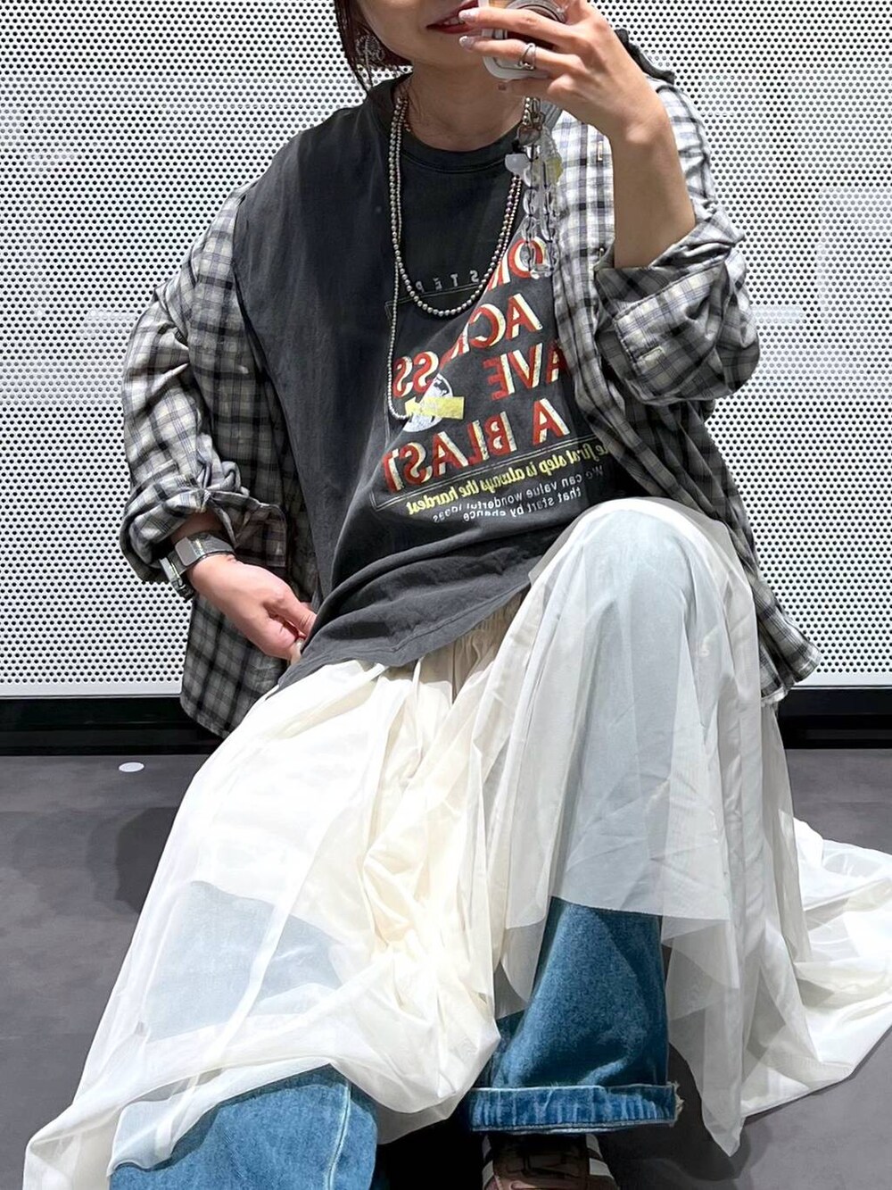 ブルー系のデニムパンツ、ベージュ系のシャツ/ブラウス、ベージュ系のスカートを着用したレディースの春コーディネートの2枚目の写真