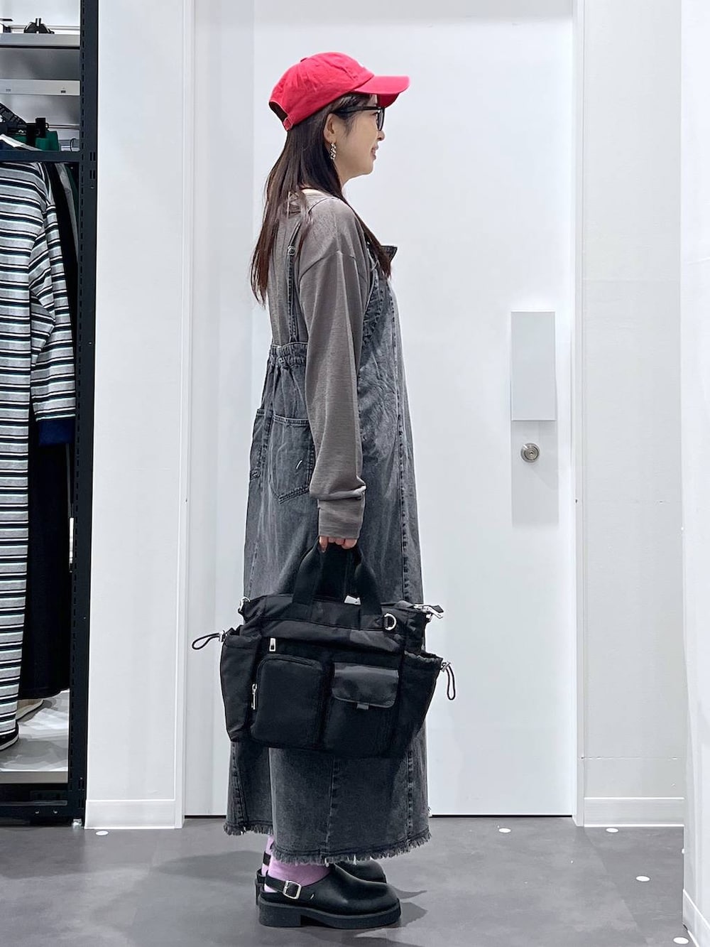 ブラック系のトートバッグ、ブラック系のサンダル、ブラック系のワンピースを着用したレディースの春コーディネートの2枚目の写真