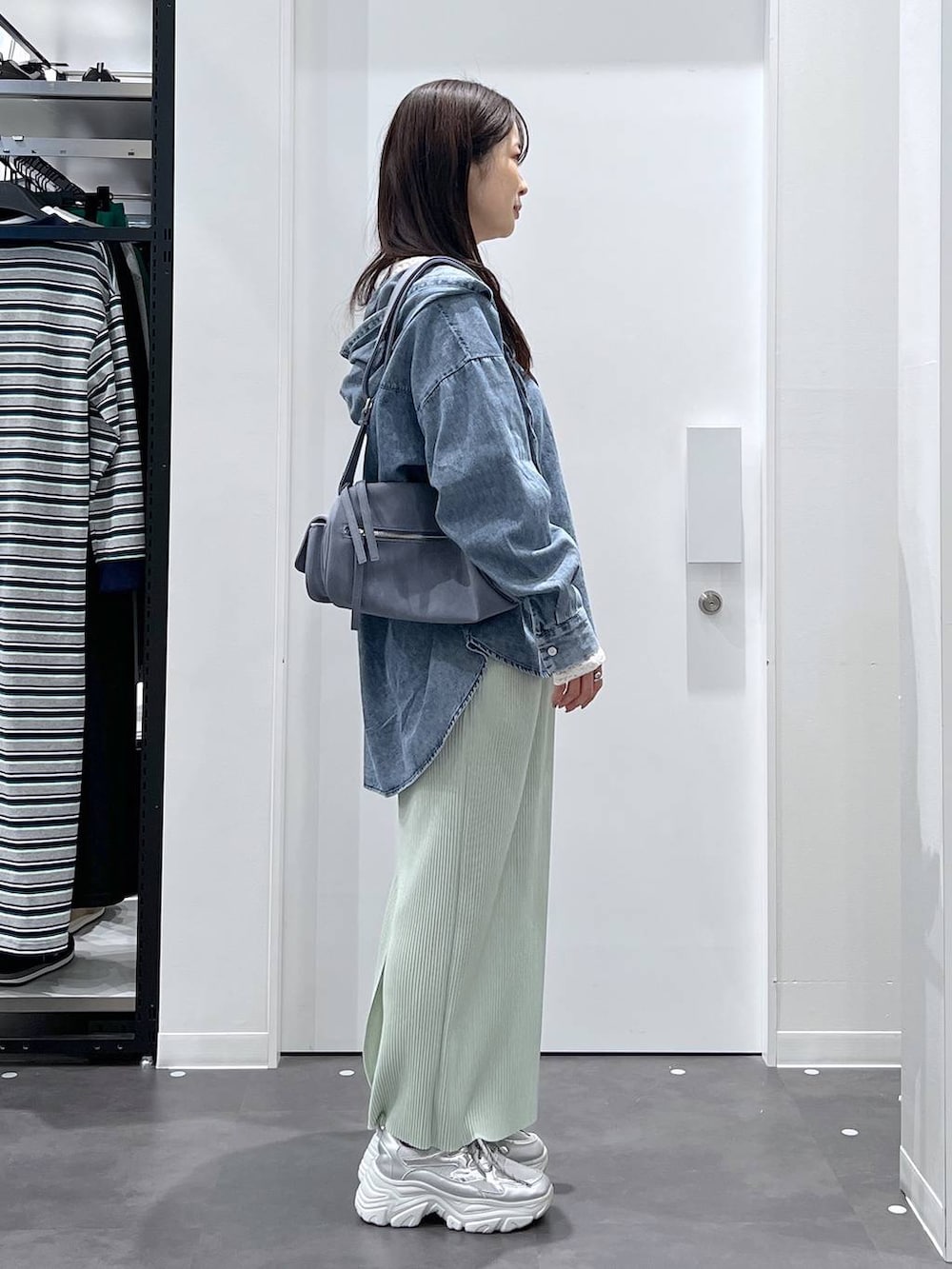 ブルー系のショルダーバッグ、ブルー系のその他トップス、ホワイト系のTシャツ/カットソーを着用したレディースの春コーディネートの2枚目の写真