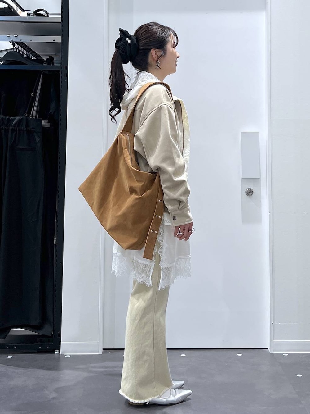 シルバー系のパンプス、イエロー系のショルダーバッグ、ホワイト系のTシャツ/カットソーを着用したレディースの春コーディネートの2枚目の写真