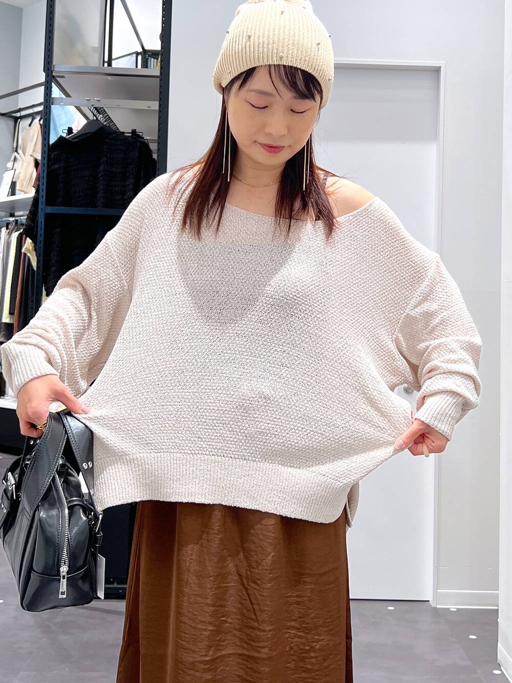 ブラック系のパンプス、ブラック系のショルダーバッグ、ブラウン系のスカートを着用したレディースの夏コーディネートの4枚目の写真