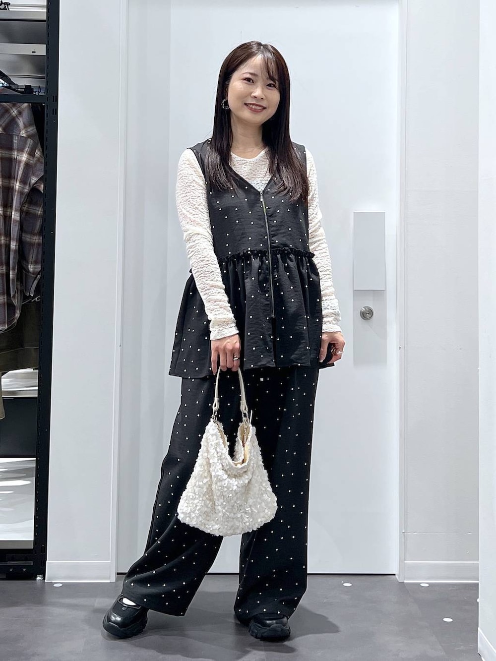 ブラック系のスニーカー、ホワイト系のTシャツ/カットソー、その他のベストを着用したレディースの冬コーディネートの5枚目の写真