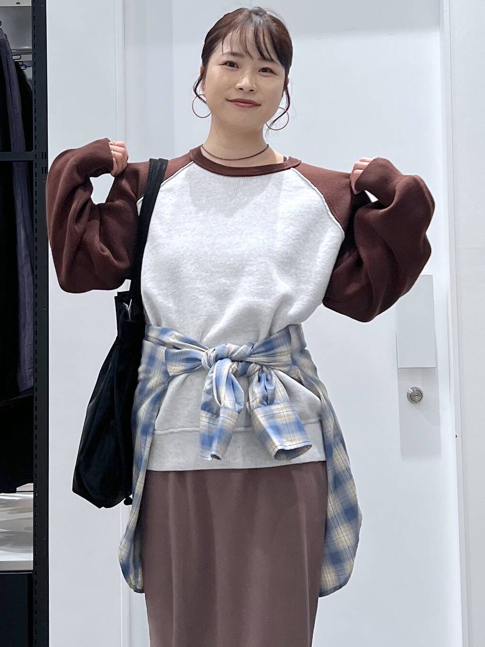 ブラック系のトートバッグ、ブラック系のブーツ、ブラウン系のニット/セーターを着用したレディースの秋コーディネートの4枚目の写真