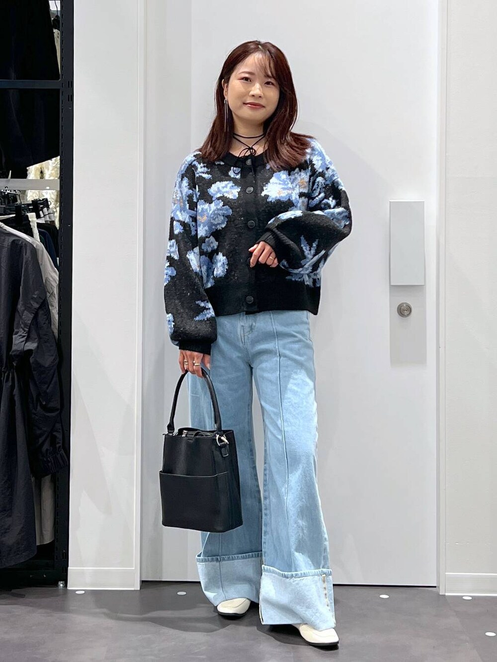 ブルー系のデニムパンツ、ブラック系のショルダーバッグ、ベージュ系のローファーを着用したレディースの秋コーディネートの2枚目の写真