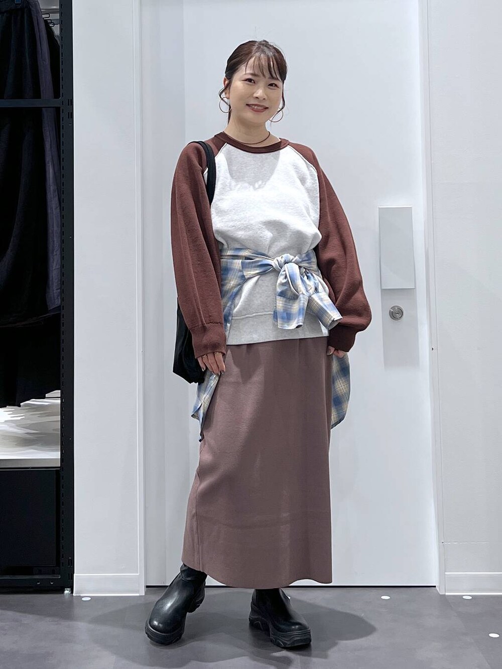 ブラック系のトートバッグ、ブラック系のブーツ、ブラウン系のニット/セーターを着用したレディースの秋コーディネートの5枚目の写真