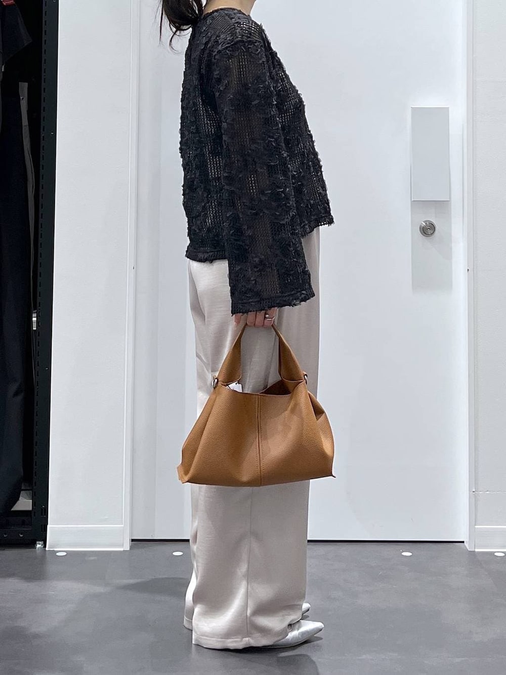 シルバー系のパンプス、ブラック系のシャツ/ブラウス、ブラウン系のトートバッグを着用したレディースの春コーディネートの2枚目の写真