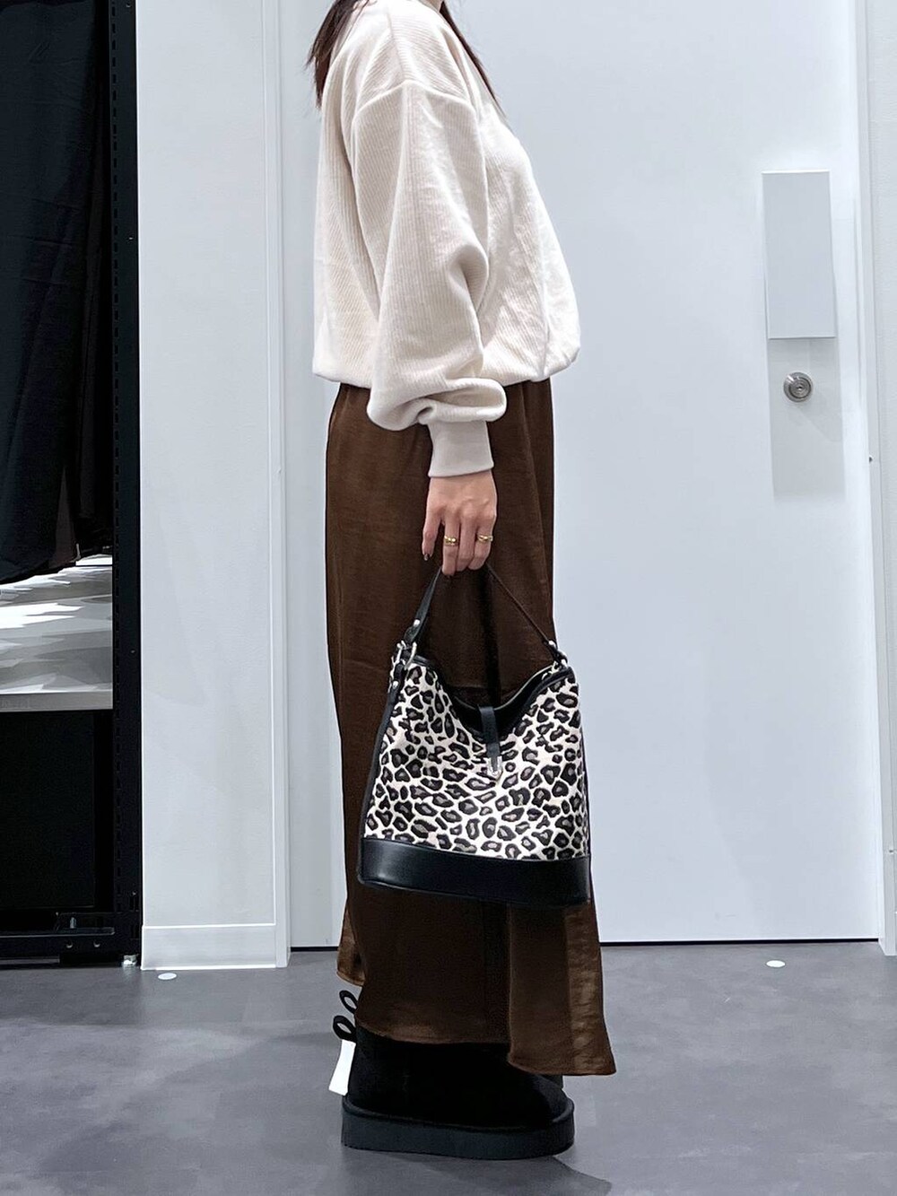 その他のショルダーバッグ、ブラウン系のスカート、ブラック系のブーツを着用したレディースの秋コーディネートの2枚目の写真